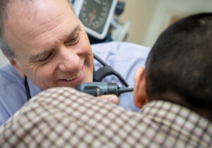 Doctor examining a patient's ear with an otoscope.