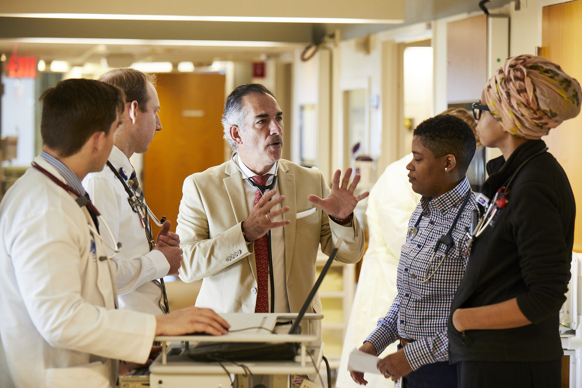 One physician speaks while four others listen