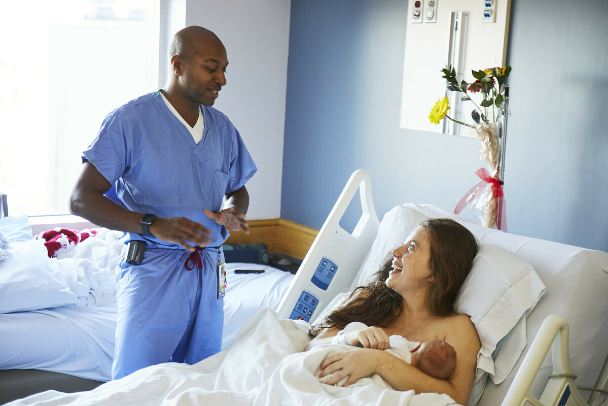 Mother and baby smiling with nurse