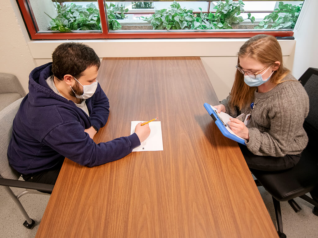 Two people at table doing paperwork